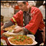 Japanese man serving food to shoppers 