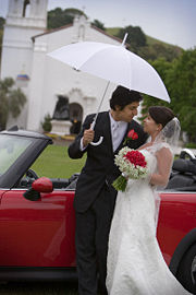 A wet wedding provides opportunity for wedding photographers to use umbrellas.